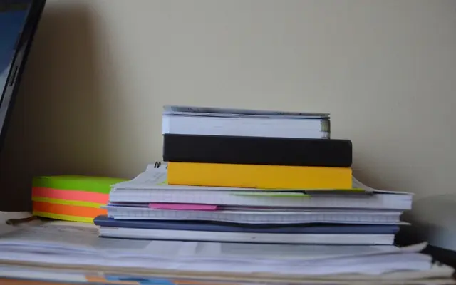 Carpetas y documentos apilados sobre un escritorio