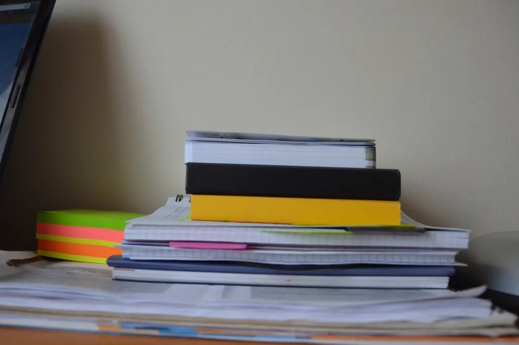 Carpetas y documentos apilados sobre un escritorio